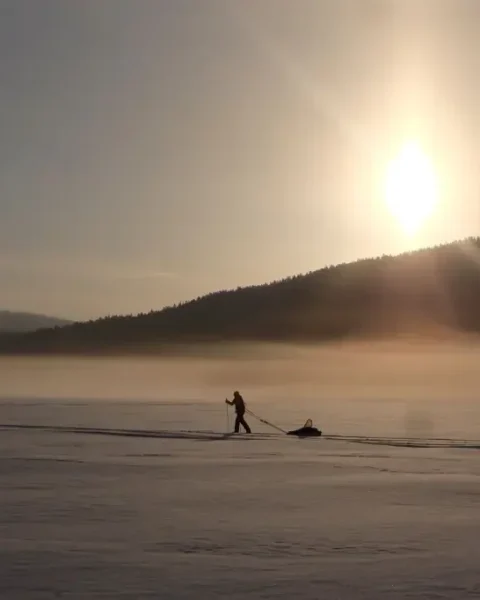 person zieht schlitten in lappland